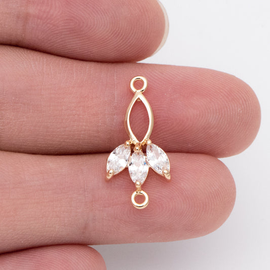 May include: Gold-tone pendant with a teardrop-shaped design and three clear marquise-shaped stones. The pendant has a jump ring at the top and bottom.