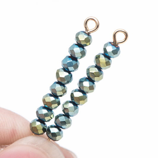 May include: Two strands of gold bead caps with green and blue iridescent beads attached.