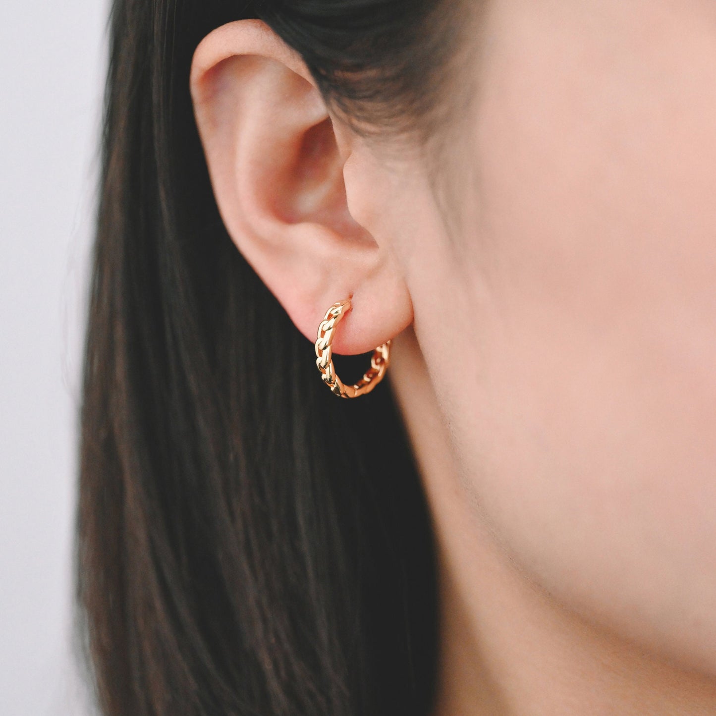 May include: Gold chain hoop earrings