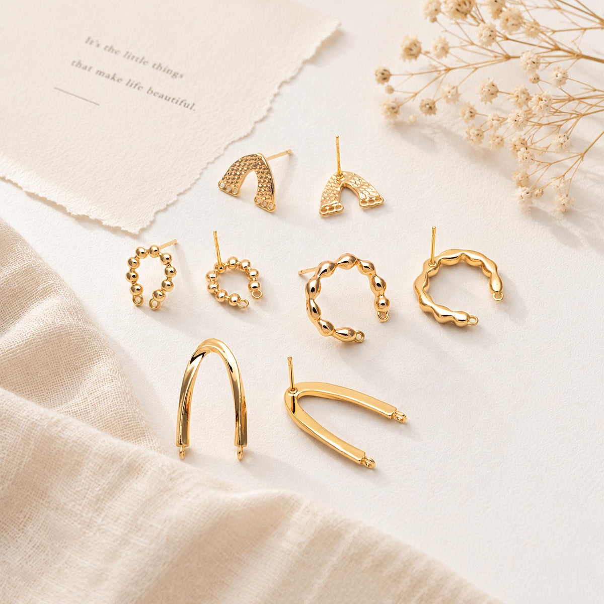 May include: A collection of gold-toned metal earrings and ear cuffs in various shapes, including textured arch designs, beaded circular hoops, and smooth U-shaped pieces. The set features multiple styles with post-back closures.
