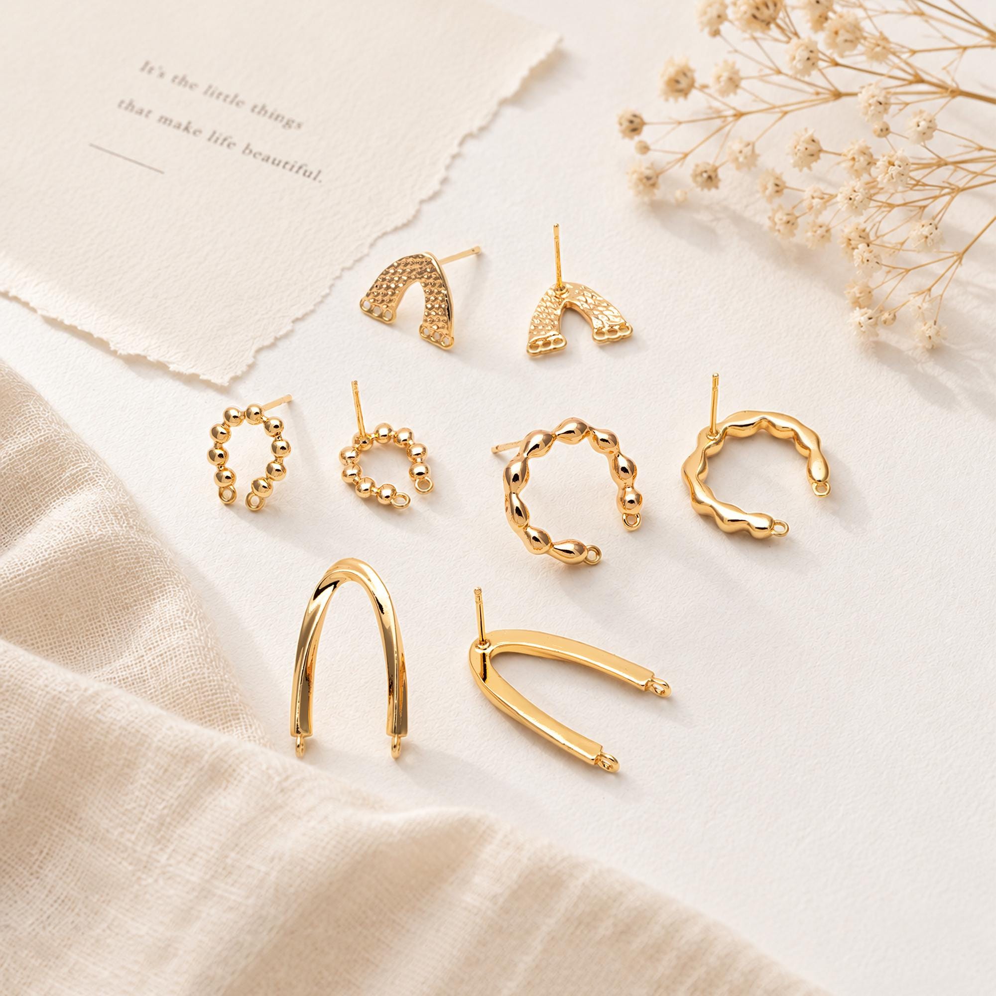May include: A collection of gold-toned metal earrings and ear cuffs in various shapes, including textured arch designs, beaded circular hoops, and smooth U-shaped pieces. The set features multiple styles with post-back closures.