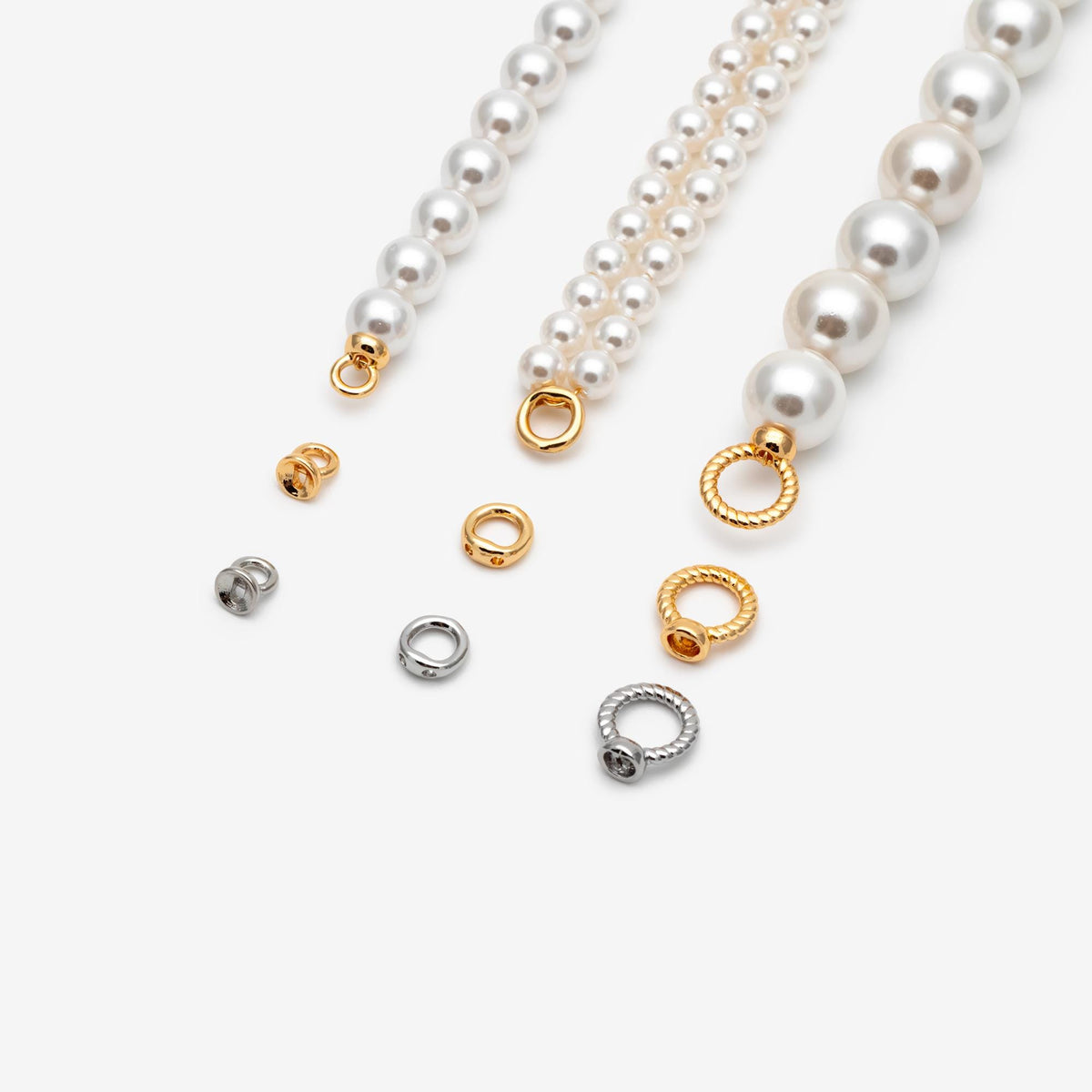 May include: Three strands of white faux pearls with gold-toned metal end caps and jump rings. The set includes additional loose gold and silver-toned metal jump rings and circular connectors with twisted and smooth textures for jewelry assembly.